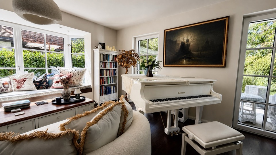 Wohnzimmer mit wei&szlig;em Fl&uuml;gel, Fensterbank und B&uuml;cherregal
